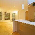 Modern kitchen with wooden flooring and appliances.