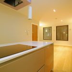 Modern kitchen with induction hob and open plan space.