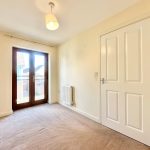 Empty room with carpet, door and window.