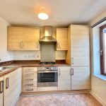 Modern kitchen with wooden cabinets and appliances.