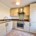 Modern kitchen with wooden cabinets and appliances.