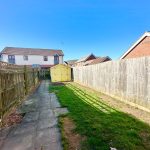 Back garden with path, grass, and shed.