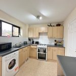 Modern kitchen with wooden cabinets and appliances.