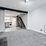 Modern living room with fireplace and staircase.