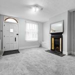 Spacious living room with fireplace and large window.