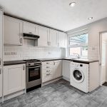 Modern kitchen with appliances and white cabinets.