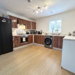 Modern kitchen with appliances and wooden cabinets.