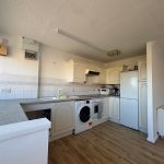 Spacious kitchen with white cabinets and appliances.