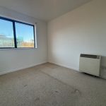 Empty room with large window and heater.