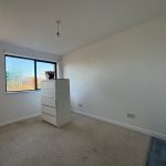 Empty bedroom with dresser and window view