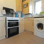 Modern kitchen with oven and washing machine.