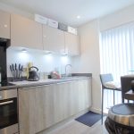 Modern kitchen with appliances and table setting.