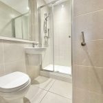 Modern bathroom with shower, sink, and toilet.