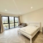 Bright bedroom with large window and bed.