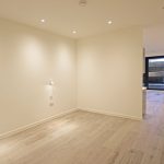 Spacious empty room with wooden flooring.