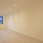 Spacious empty room with wooden flooring.