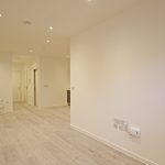 Modern empty room with wooden floor and spotlights.