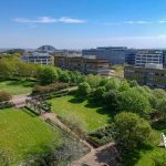 Aerial view of campus buildings and green park.