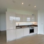 Modern kitchen with appliances and large window view.