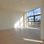 Modern flat with large windows and wooden floor.