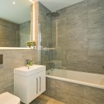 Modern bathroom with grey tiles and bathtub