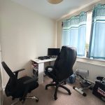 Home office with two chairs and blue curtains.