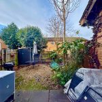 Small backyard with table, chairs, and plants.