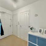 Minimalist hallway with white doors and decor.