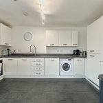 Modern kitchen with appliances and white cabinets.