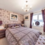 Cosy bedroom with floral decor and chandelier.