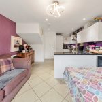 Cosy kitchen and living area with sofa, purple walls