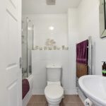 Modern white bathroom interior with towel rail.