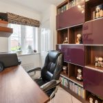 Home office with desk, chair, and shelves.