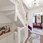 Modern hallway with staircase and art on walls.