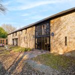 Stone barn conversion with large windows and garden