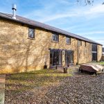 Stone house exterior with patio and garden area.