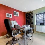 Modern home office with red walls and desk