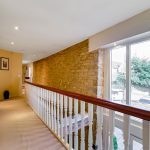 Modern hallway with wooden railing and large window