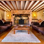 Cosy rustic living room with fireplace and sofas.