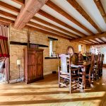 Rustic dining room with wooden beams and furniture.