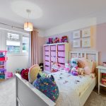 Child's bedroom with toys and storage units.