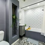 Modern bathroom with plants and patterned floor tiles.