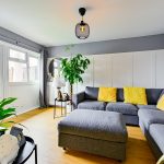 Bright living room with grey sofa and yellow cushions.