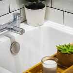 Bathroom tap and toiletries on bathtub tray