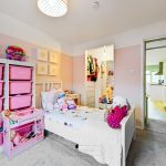 Colourful children's bedroom with toys and storage bins.