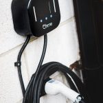 Electric vehicle charger mounted on brick wall