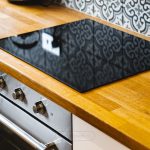 Modern kitchen hob and oven on wooden counter