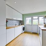 Modern kitchen with light wood floors and patterned tiles.