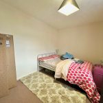 Cosy bedroom with suitcase and cardboard box.