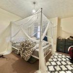 Bedroom with canopy bed and dresser